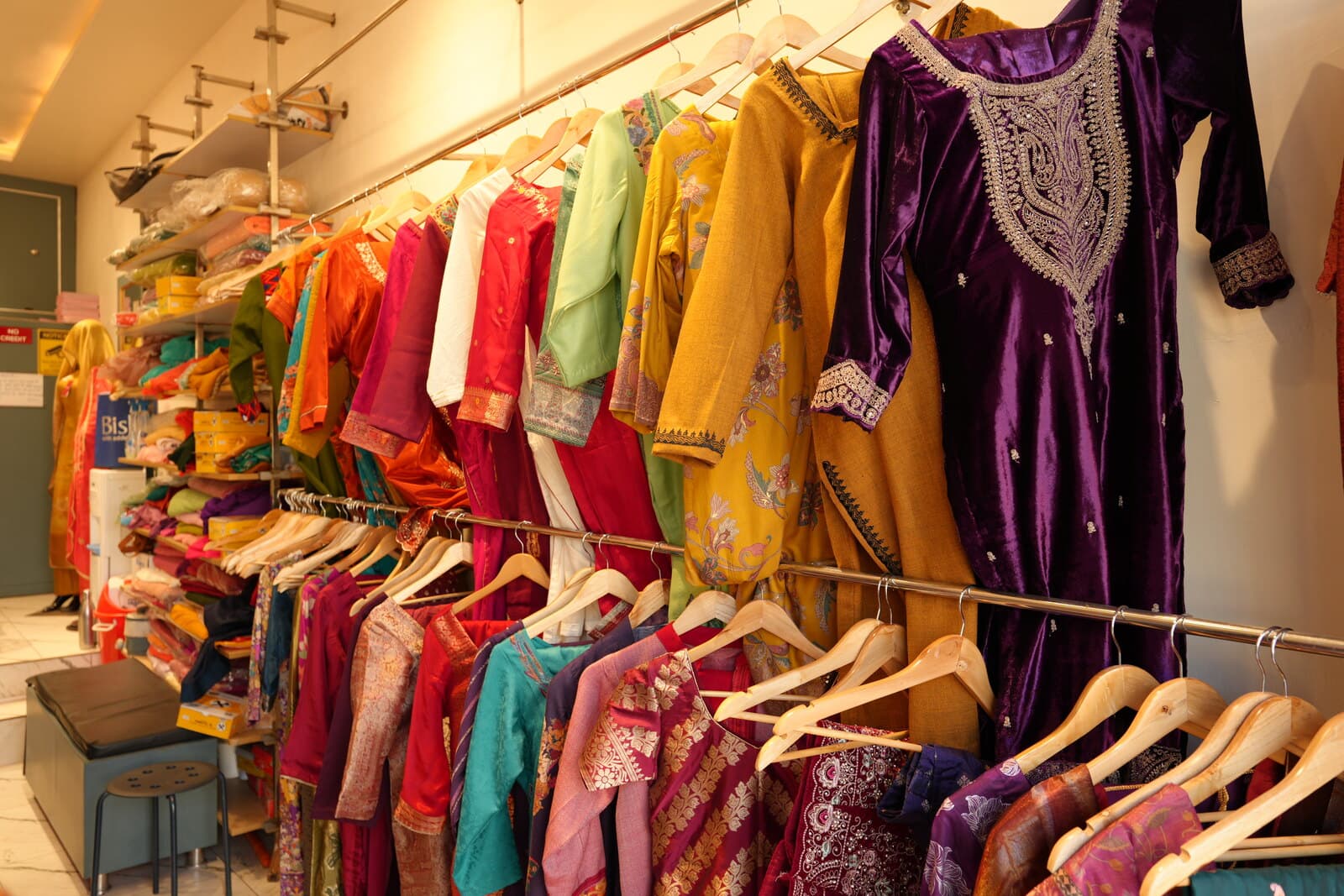 Rack of stitched kurtas in the studio.